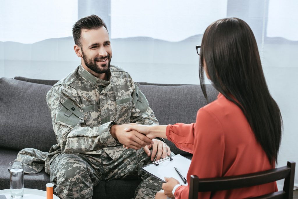 smiling-soldier-shaking-hand-of-psychiatrist-during-therapy-session